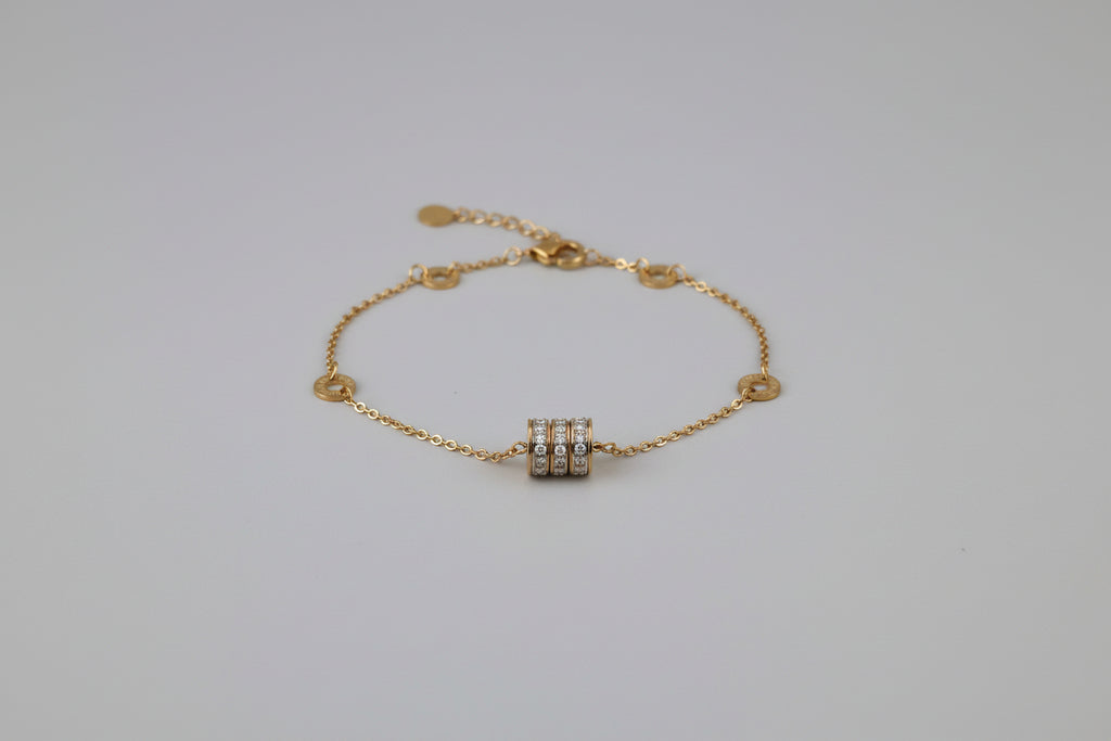 Gold necklace on a decorative white stand with floral patterns