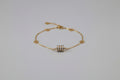 Gold necklace on a decorative white stand with floral patterns